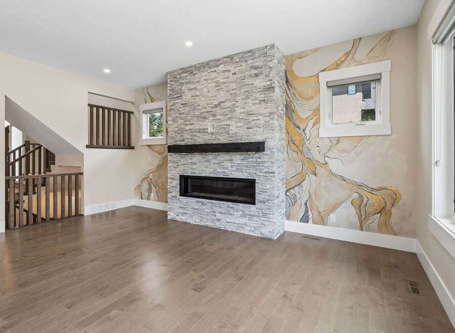 Experience modern living in this stunning great room, featuring a striking stacked stone fireplace as the focal point.