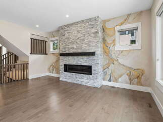 Experience modern living in this stunning great room, featuring a striking stacked stone fireplace as the focal point.