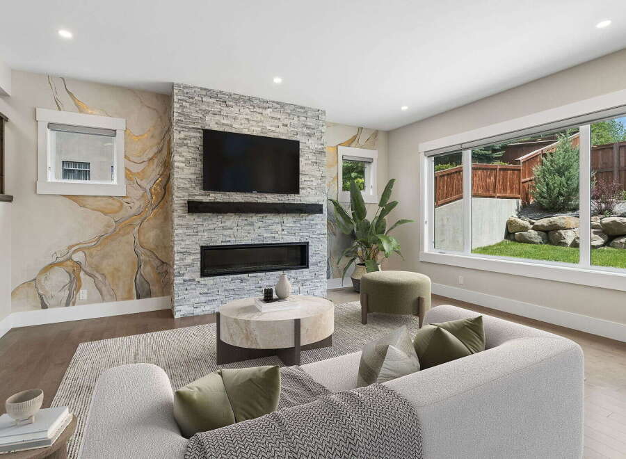 Experience modern living in this stunning living room, featuring a striking stone fireplace and a large television perfect for entertainment.
