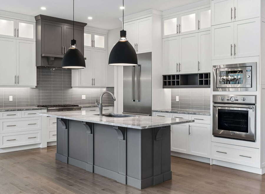 Experience luxury in this stunning modern kitchen, featuring sleek white cabinetry and a sophisticated gray island.