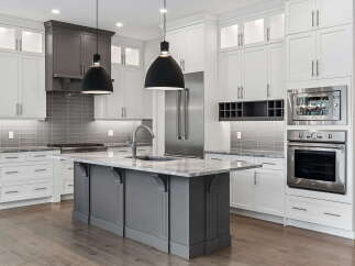 Experience luxury in this stunning modern kitchen, featuring sleek white cabinetry and a sophisticated gray island.