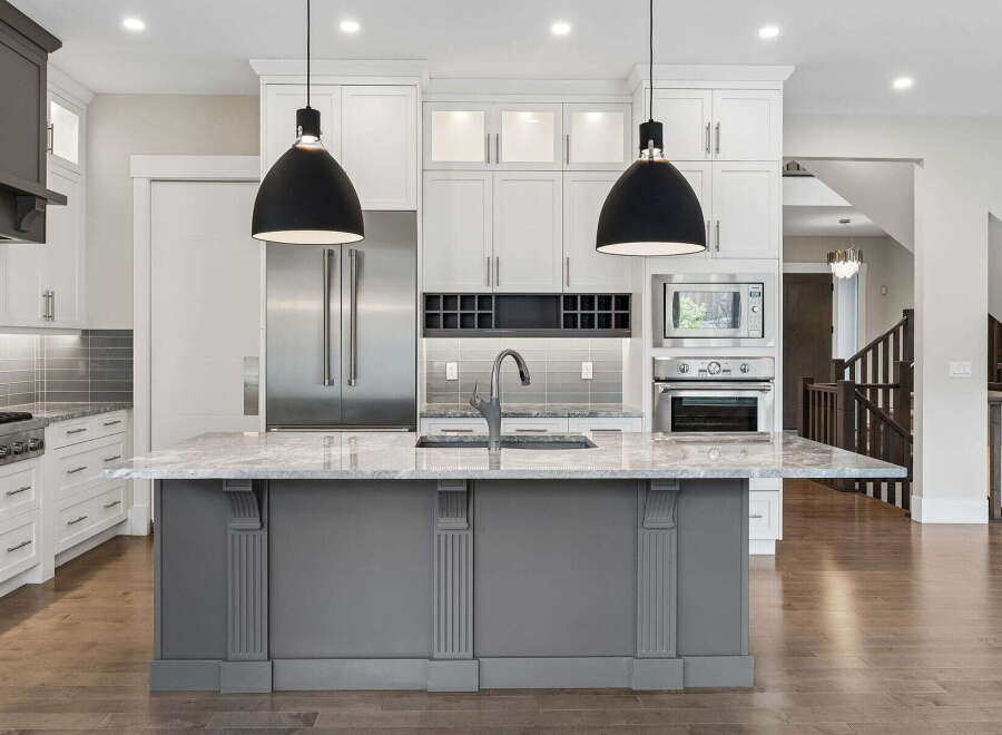 Experience luxury in this stunning modern kitchen, featuring a spacious island with a sleek faucet and ample counter space.