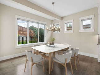 Experience elegant dining in this beautifully appointed space, featuring a stunning marble-top table surrounded by comfortable, modern chairs.
