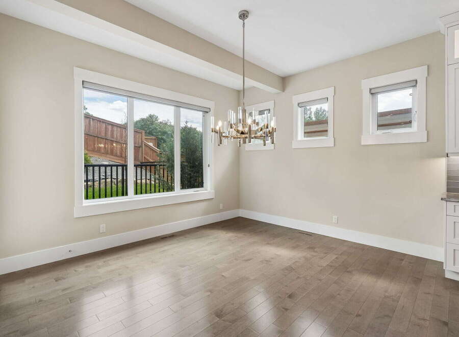 Experience modern living in this elegant dining area, featuring a stunning chandelier that illuminates the space.