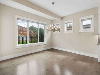 Experience modern living in this elegant dining area, featuring a stunning chandelier that illuminates the space.