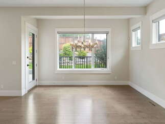 Step into this bright and airy dining room, featuring a stunning modern chandelier that illuminates the space.