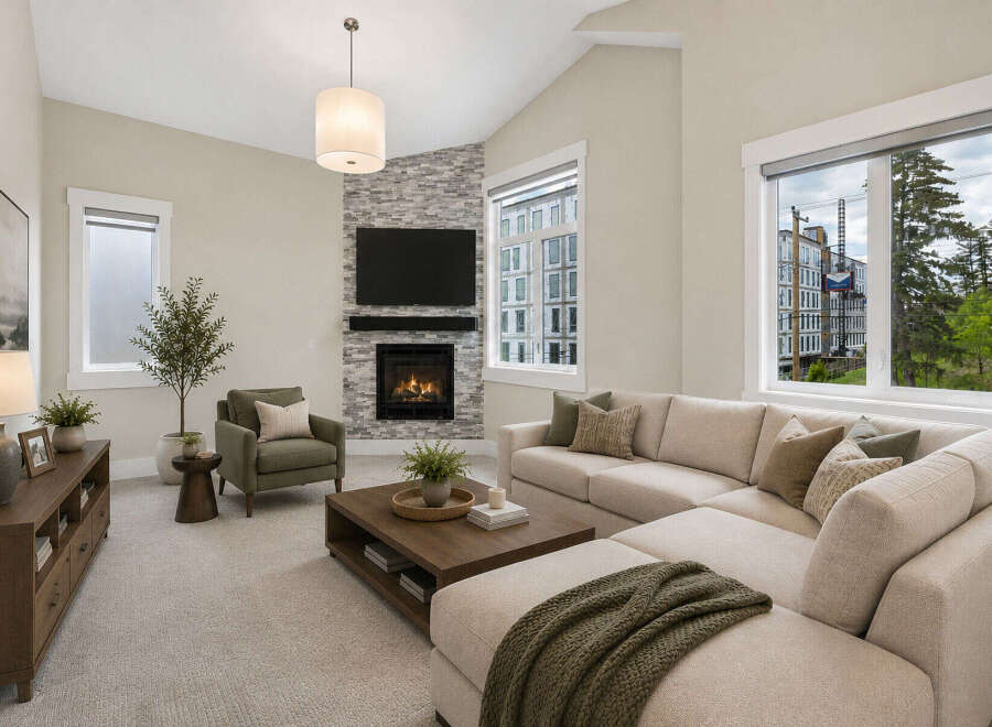 Experience modern living in this spacious living room, featuring a cozy fireplace with a stone accent wall and a large sectional sofa perfect for gatherings.