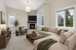 Experience modern living in this spacious living room, featuring a cozy fireplace with a stone accent wall and a large sectional sofa perfect for gatherings.