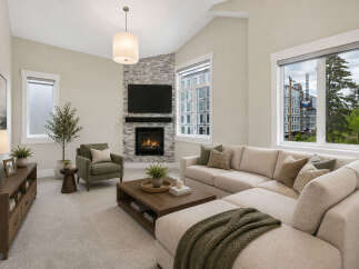 Experience modern living in this spacious living room, featuring a cozy fireplace with a stone accent wall and a large sectional sofa perfect for gatherings.