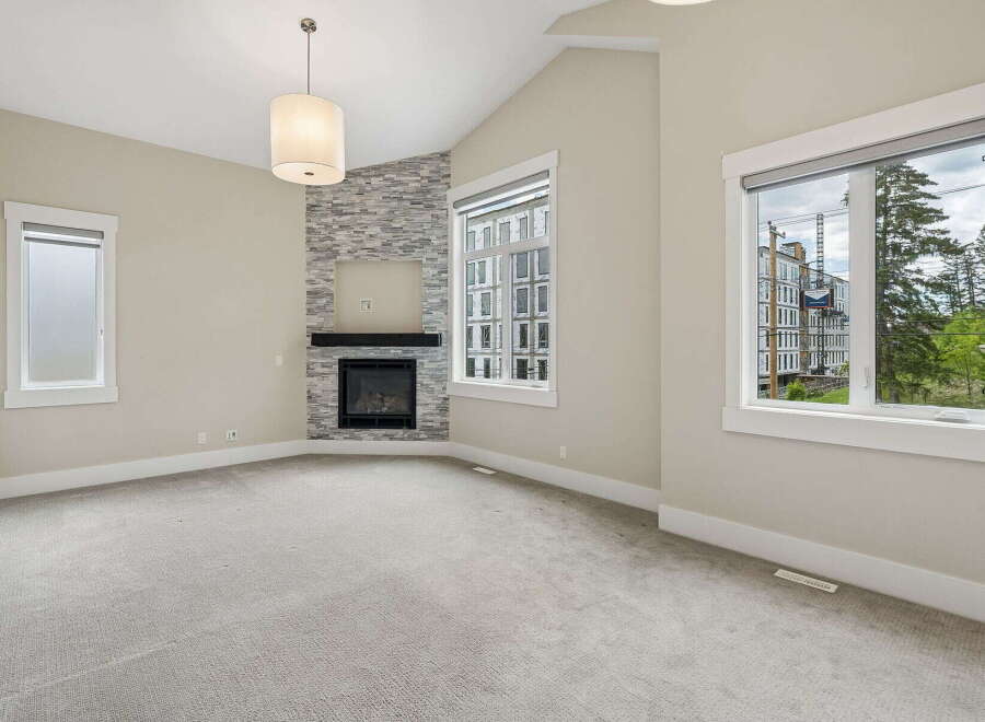 Experience modern living in this spacious room featuring a striking stone-accented fireplace as the focal point.