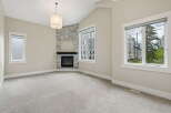 Experience modern living in this spacious room featuring a striking stone-accented fireplace as the focal point.