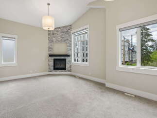 Experience modern living in this spacious room featuring a striking stone-accented fireplace as the focal point.