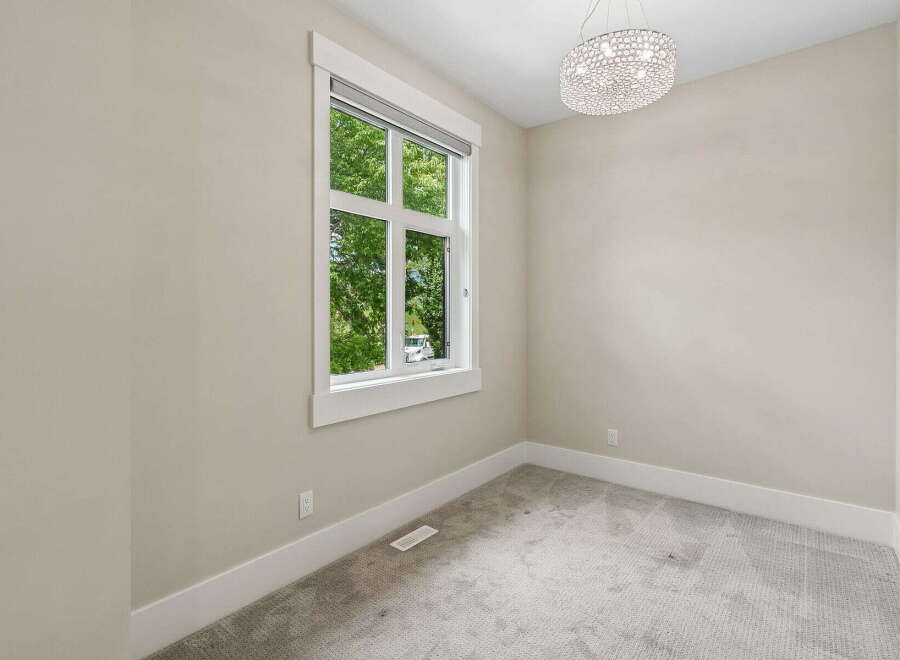 This bright and airy room features a large window offering views of lush greenery.