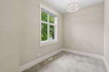 This bright and airy room features a large window offering views of lush greenery.