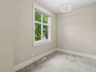 This bright and airy room features a large window offering views of lush greenery.