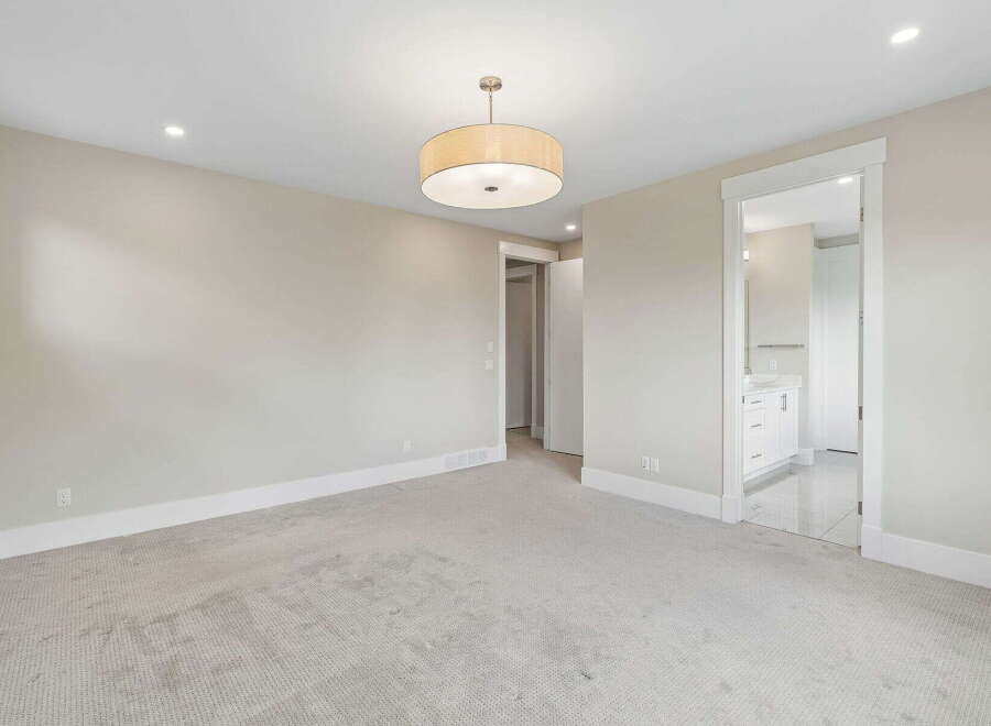 Step into this spacious bedroom featuring a neutral color palette and plush carpeting for ultimate comfort.