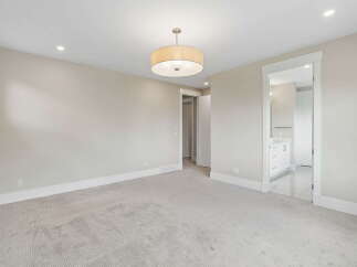 Step into this spacious bedroom featuring a neutral color palette and plush carpeting for ultimate comfort.