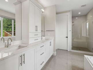 Experience luxury in this modern bathroom featuring a spacious double vanity with sleek cabinetry and quartz countertops.