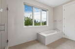 Experience luxury in this modern bathroom featuring a spacious soaking tub with a stunning city view.