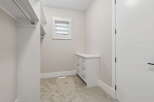 Step into this spacious walk-in closet, featuring ample hanging space and a built-in dresser for organized storage.