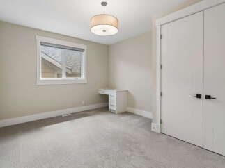 This bright and airy bedroom features a modern white desk with ample drawer space, perfect for a home office or study area.