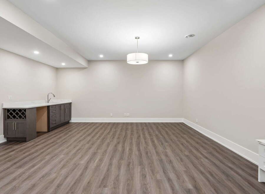 Discover this beautifully finished basement, featuring a modern wet bar with ample cabinet space and a wine rack, perfect for entertaining.