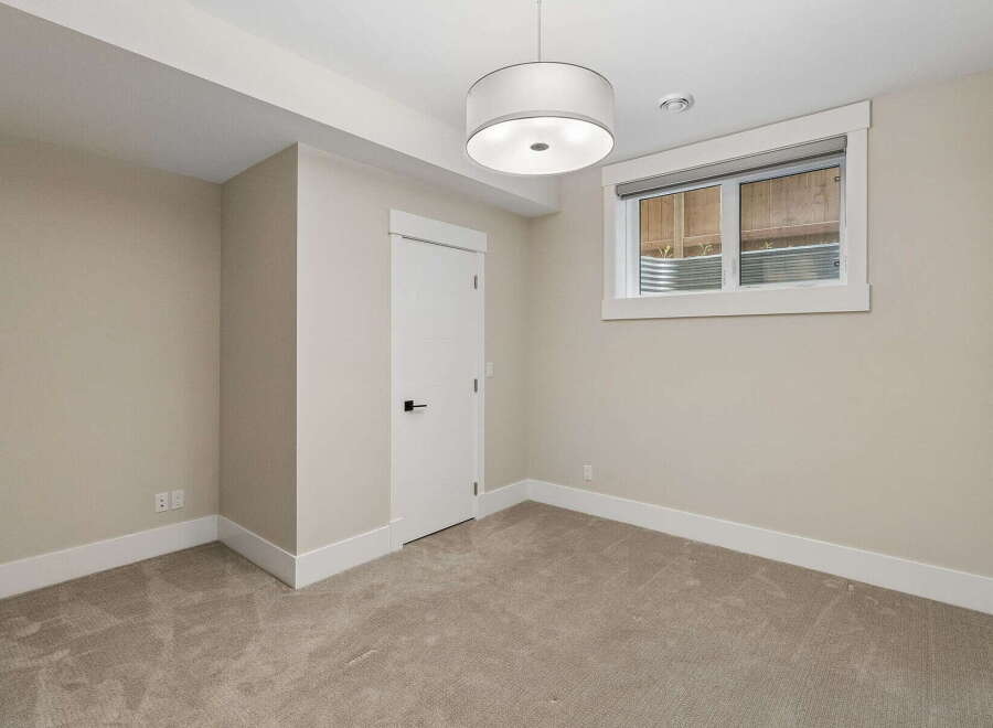 This unfurnished room features neutral-toned walls and carpeting, creating a versatile canvas for any decor style.