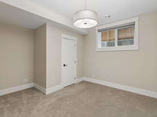 This unfurnished room features neutral-toned walls and carpeting, creating a versatile canvas for any decor style.
