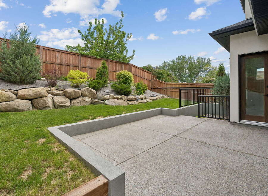 Step outside to a beautifully landscaped backyard featuring a spacious concrete patio, perfect for entertaining.