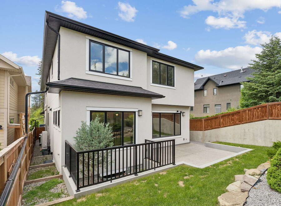 Discover modern living in this stunning home featuring a sleek stucco exterior and large, black-framed windows that flood the interior with natural light.