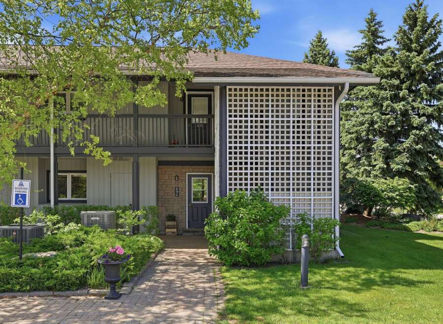 Discover this charming property featuring a welcoming brick entrance and a decorative white lattice screen.