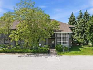 Discover this charming property featuring a welcoming entrance with a decorative lattice screen and a paved walkway leading to the front door.