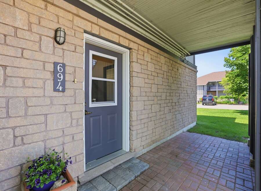 Welcome to this charming property featuring a welcoming front entrance with a stylish dark blue door and a decorative light fixture.