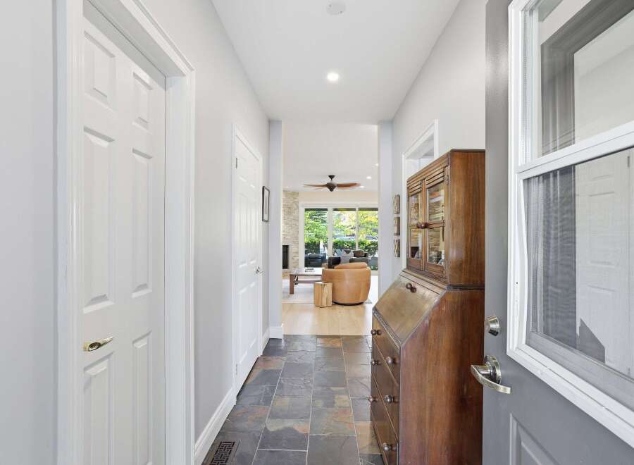 Step into a welcoming foyer featuring slate tile flooring and a charming antique secretary desk.