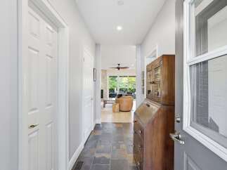 Step into a welcoming foyer featuring slate tile flooring and a charming antique secretary desk.