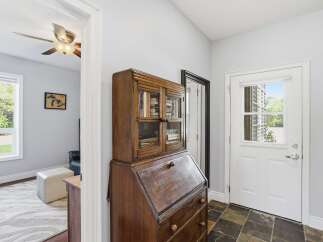 Discover charm and functionality in this inviting entryway, featuring a classic wooden secretary desk perfect for organizing your essentials.