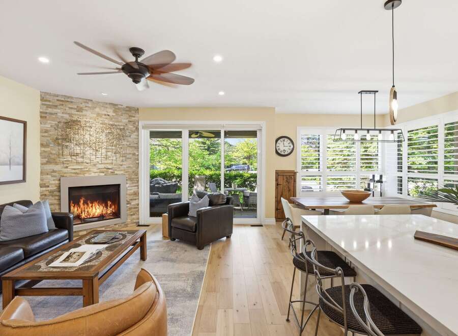 Experience luxurious open-concept living with a stunning stone fireplace as the centerpiece of this inviting living area.