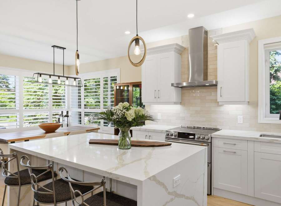 Experience modern luxury in this stunning kitchen, featuring a spacious island with a quartz countertop and elegant pendant lighting.