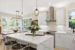 Experience modern luxury in this stunning kitchen, featuring a spacious island with a quartz countertop and elegant pendant lighting.