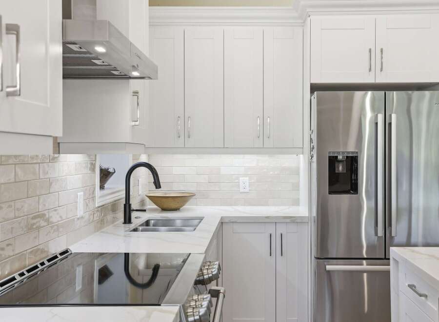 Experience modern elegance in this stunning kitchen, featuring sleek white cabinetry and a durable quartz countertop.