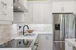 Experience modern elegance in this stunning kitchen, featuring sleek white cabinetry and a durable quartz countertop.