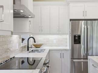 Experience modern elegance in this stunning kitchen, featuring sleek white cabinetry and a durable quartz countertop.