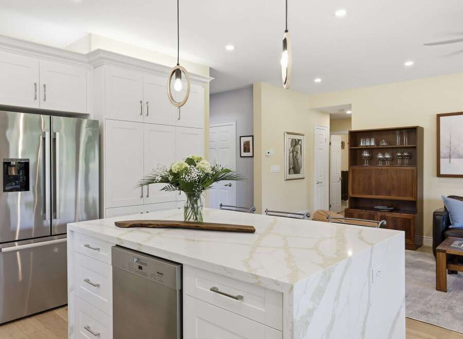 Experience modern living in this stunning kitchen, featuring sleek white cabinetry and a luxurious marble island perfect for entertaining.