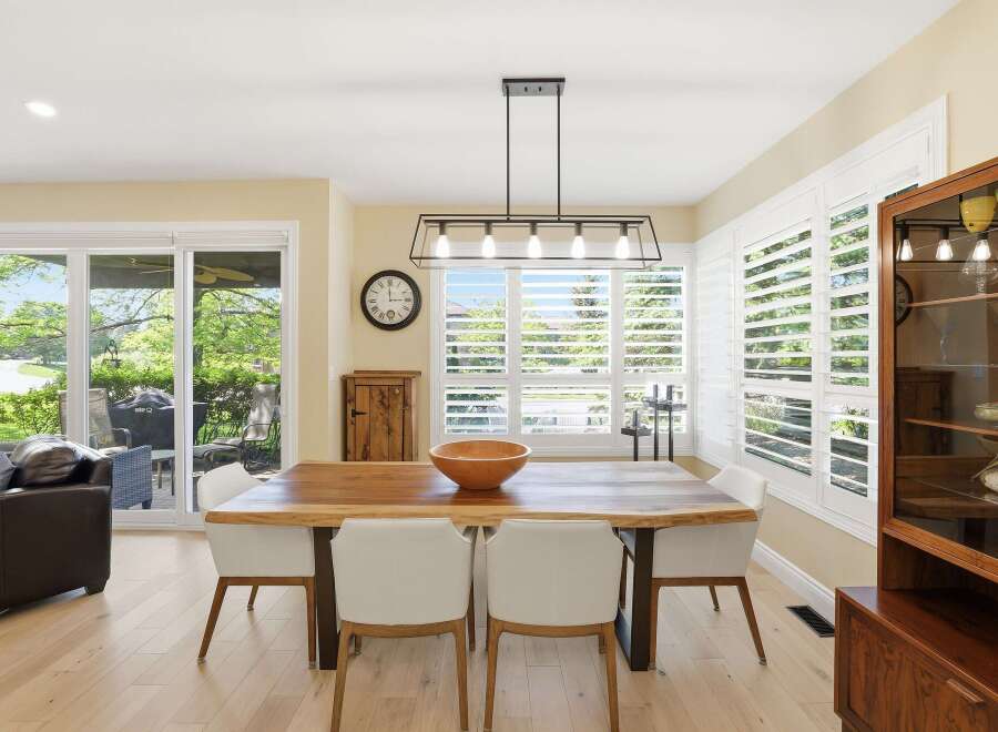 Experience elegant dining in this beautifully appointed space, featuring a live-edge wood table complemented by modern white chairs.