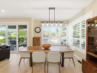 Experience elegant dining in this beautifully appointed space, featuring a live-edge wood table complemented by modern white chairs.