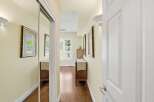 Step into this inviting hallway, featuring a mirrored closet and warm hardwood floors.