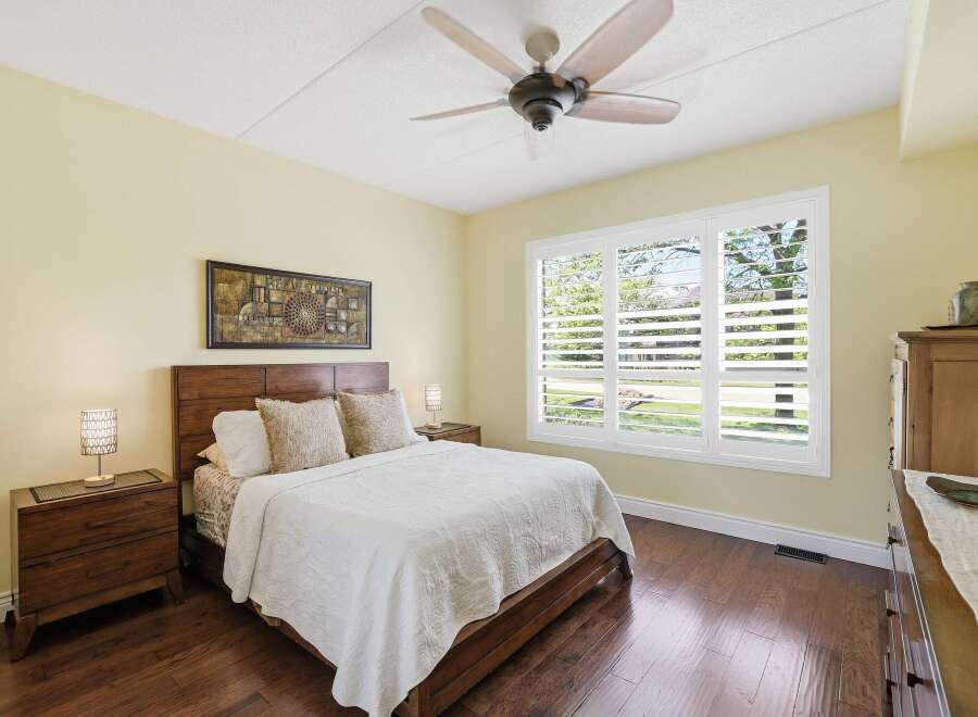 Experience comfort and style in this beautifully appointed bedroom, featuring a plush queen-size bed adorned with textured pillows and a crisp white quilt.