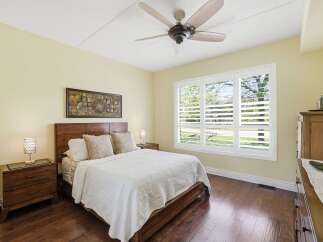 Experience comfort and style in this beautifully appointed bedroom, featuring a plush queen-size bed adorned with textured pillows and a crisp white quilt.
