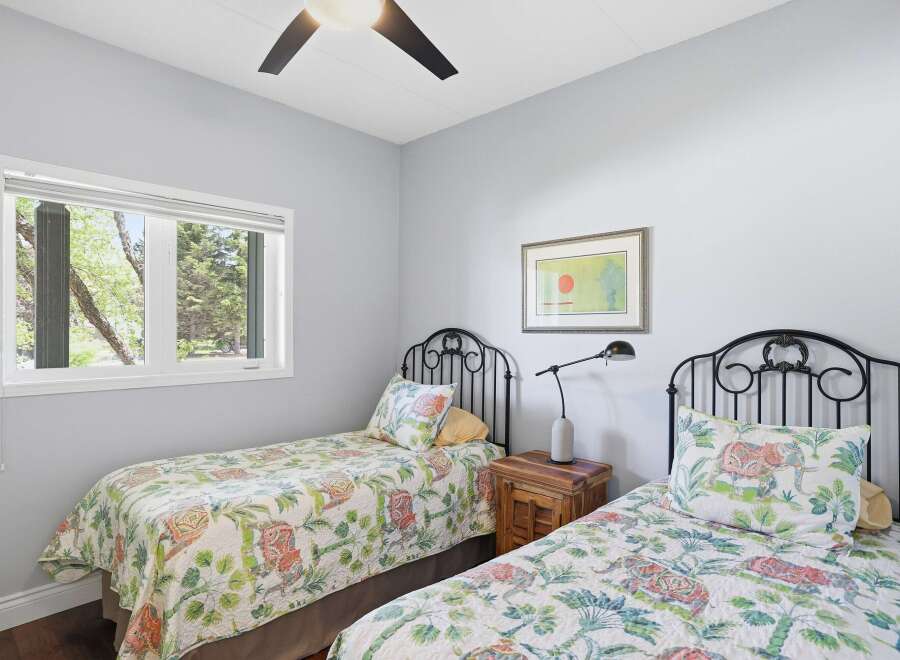 This charming bedroom features two twin beds with decorative headboards, perfect for guests or children.