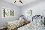 This charming bedroom features two twin beds with decorative headboards, perfect for guests or children.